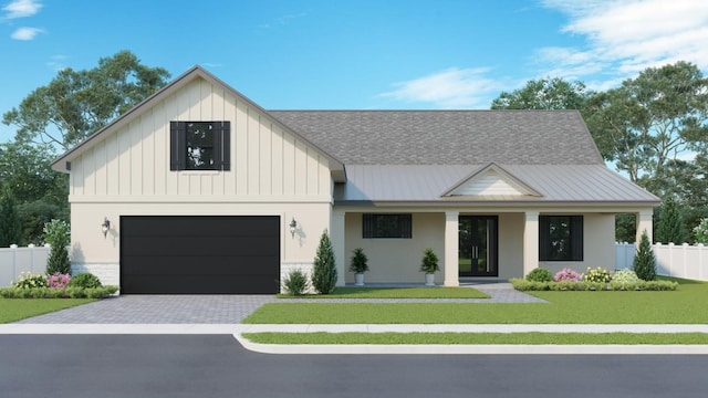 modern farmhouse featuring a front yard and a garage