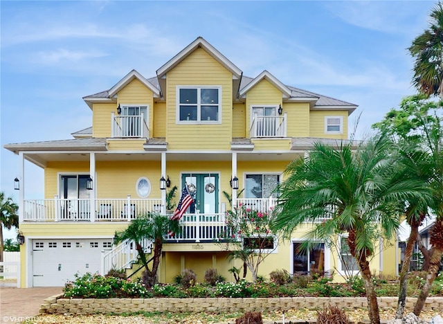 view of front of property with a porch, a balcony, and a garage