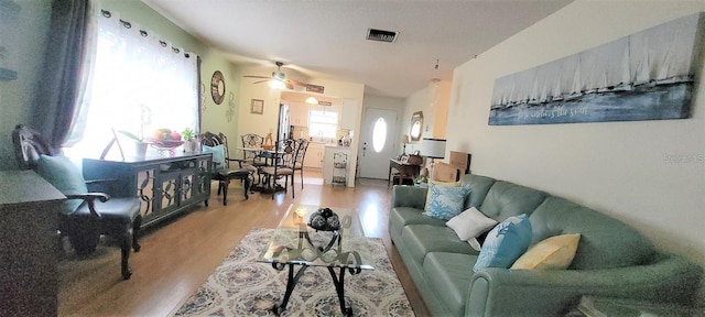 living room featuring plenty of natural light, ceiling fan, and light wood-type flooring