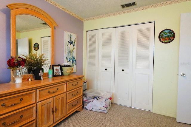 carpeted bedroom with a closet and a textured ceiling