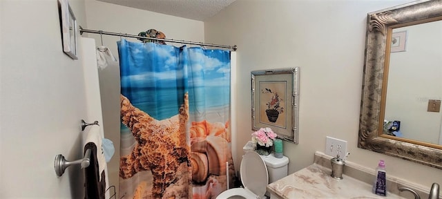 bathroom featuring toilet, a textured ceiling, and vanity