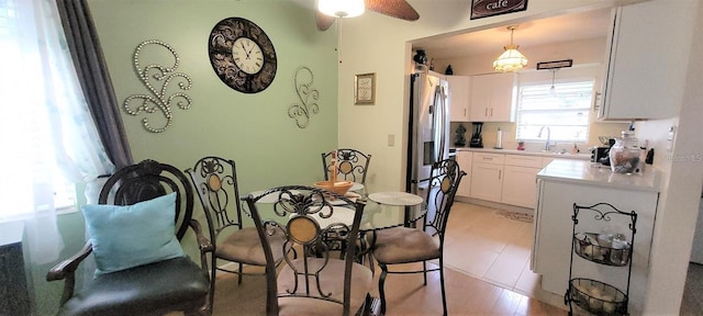 dining space featuring light tile floors, ceiling fan, and sink