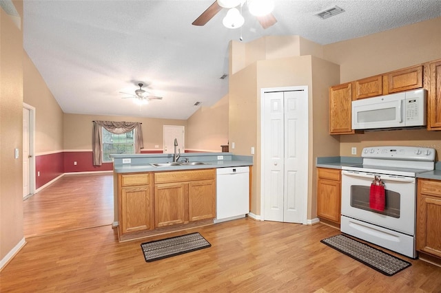 kitchen featuring ceiling fan, sink, white appliances, light wood-type flooring, and lofted ceiling