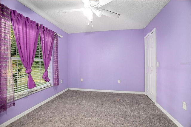 carpeted empty room with ceiling fan and a textured ceiling