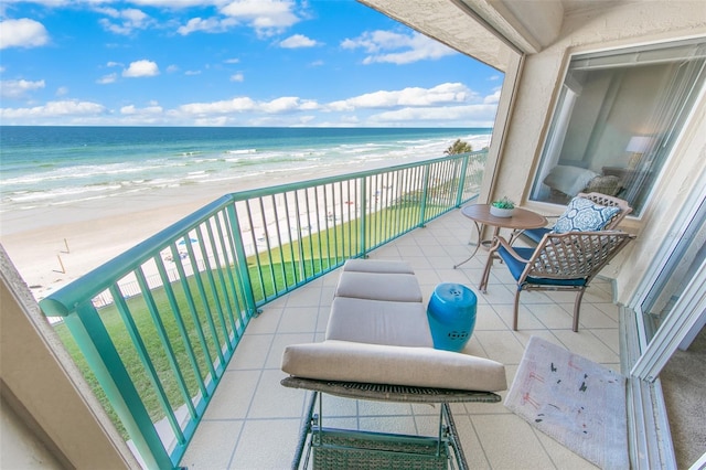 balcony featuring a water view and a view of the beach