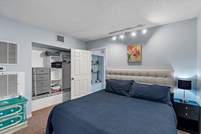 carpeted bedroom with a textured ceiling and track lighting