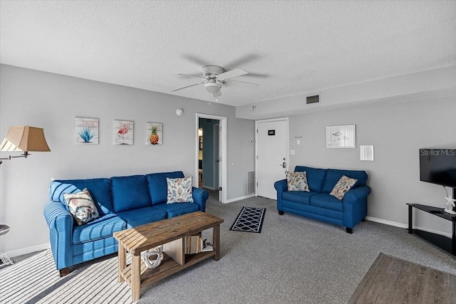 living room featuring a textured ceiling, ceiling fan, and dark colored carpet