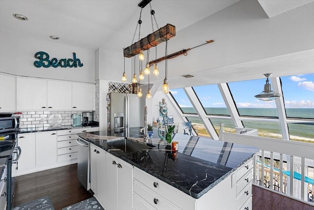 kitchen featuring tasteful backsplash, white cabinetry, a wealth of natural light, and a center island