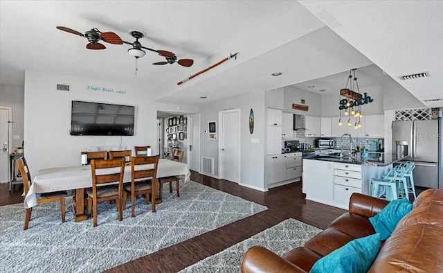 living room with dark wood-type flooring, ceiling fan, and sink