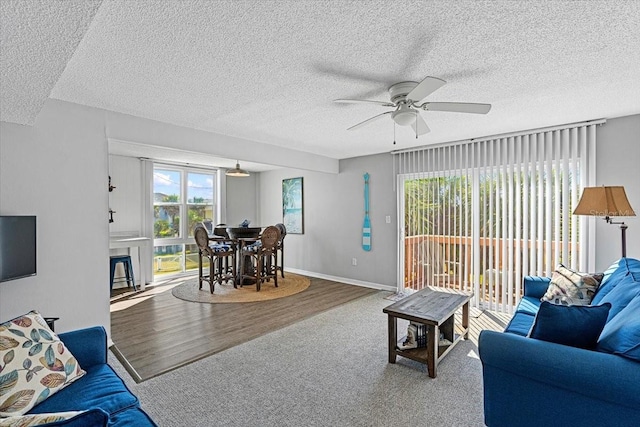 carpeted living room with ceiling fan and a textured ceiling