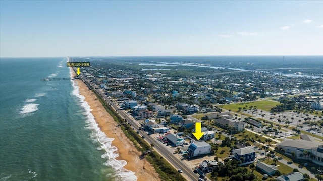 drone / aerial view with a water view and a beach view