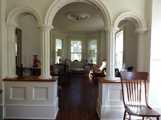 interior space featuring dark hardwood / wood-style floors and ornate columns