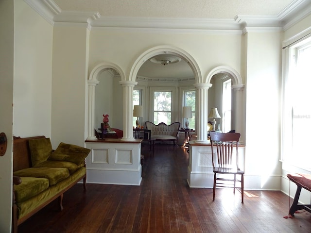 entrance foyer with plenty of natural light, crown molding, decorative columns, and dark hardwood / wood-style flooring