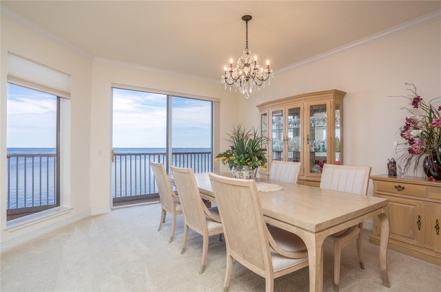 dining space with light carpet, ornamental molding, a water view, and a notable chandelier