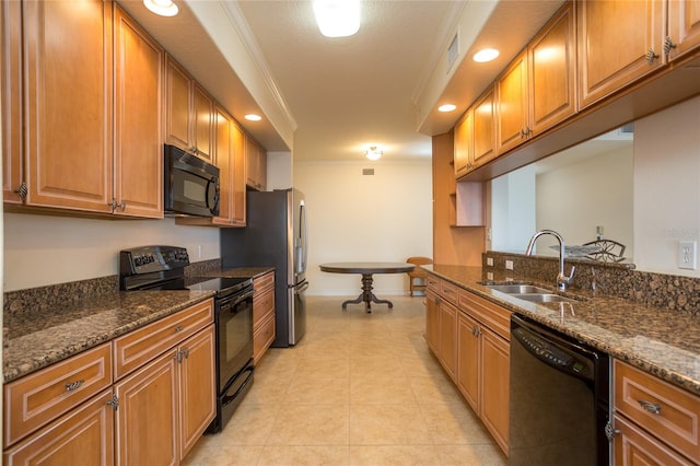 kitchen with dark stone countertops, crown molding, sink, and black appliances