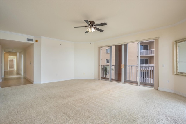 carpeted spare room with ceiling fan and ornamental molding