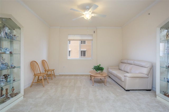 sitting room with ceiling fan, light colored carpet, and ornamental molding