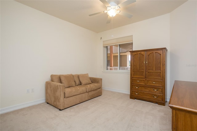 living area with light carpet and ceiling fan