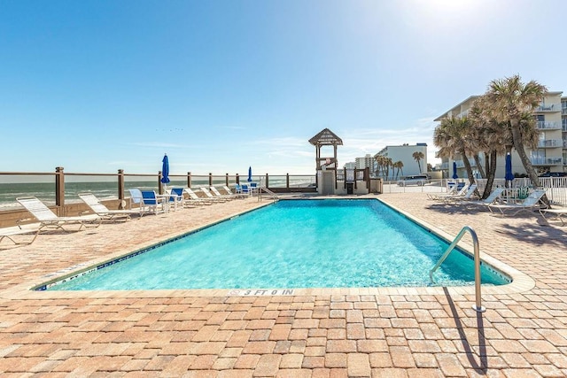 view of swimming pool with a patio area and a water view