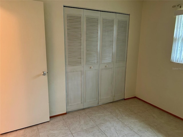 unfurnished bedroom featuring a closet and light tile patterned flooring