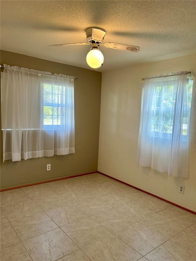 unfurnished room featuring ceiling fan and a textured ceiling