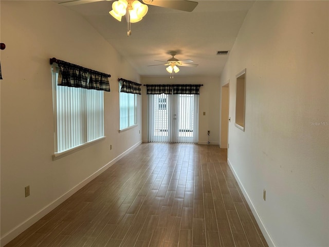 spare room with dark wood-type flooring, lofted ceiling, and ceiling fan