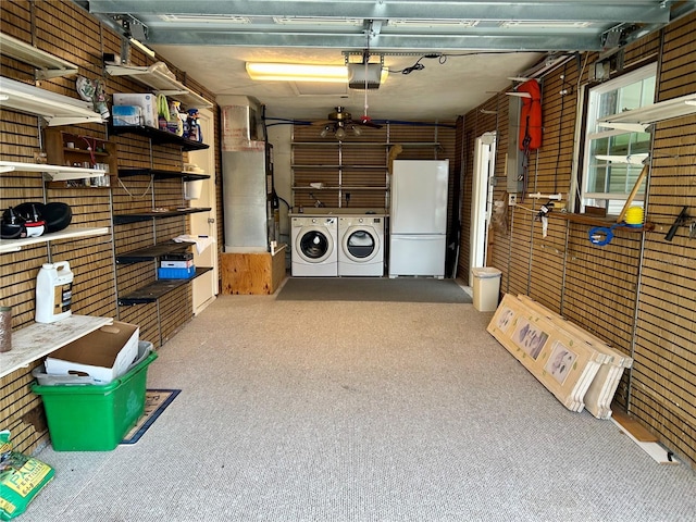 garage with washing machine and dryer, a garage door opener, and white refrigerator