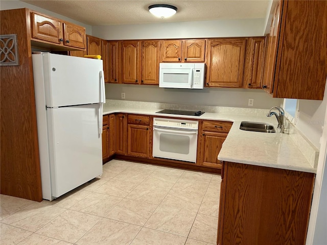 kitchen with sink, white appliances, a textured ceiling, and light tile patterned flooring