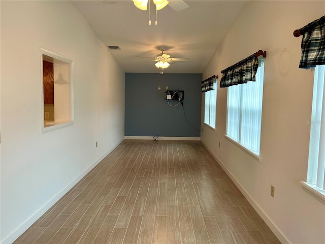 unfurnished room featuring ceiling fan, a healthy amount of sunlight, and hardwood / wood-style floors