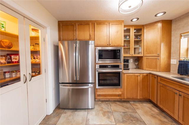 kitchen featuring light tile floors, light stone counters, and stainless steel appliances