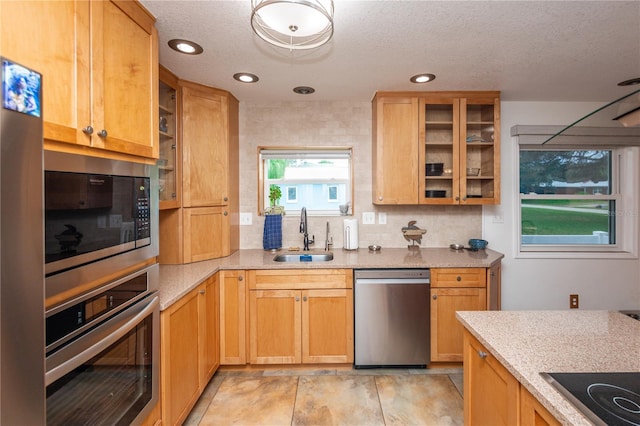 kitchen featuring light tile flooring, sink, stainless steel appliances, a textured ceiling, and tasteful backsplash