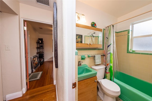 full bathroom with shower / bath combo with shower curtain, toilet, vanity, and wood-type flooring