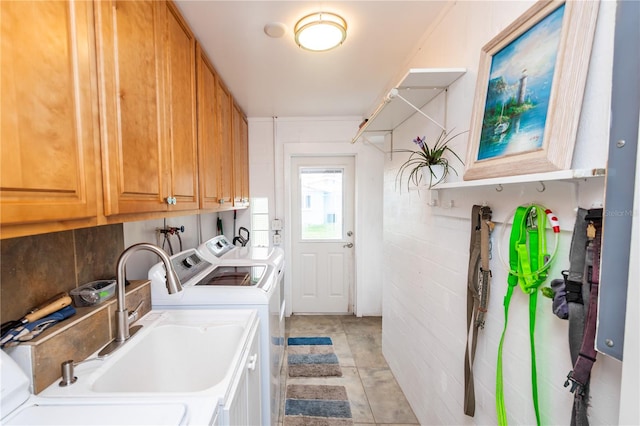 washroom featuring washer hookup, sink, light tile floors, cabinets, and separate washer and dryer