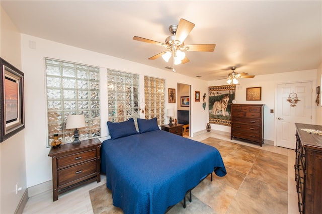 bedroom with light tile flooring, multiple windows, and ceiling fan