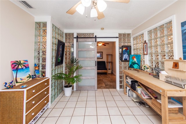 interior space featuring a textured ceiling, ceiling fan, and light tile flooring