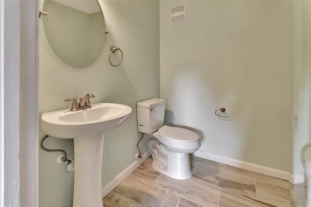 bathroom with baseboards, visible vents, and toilet