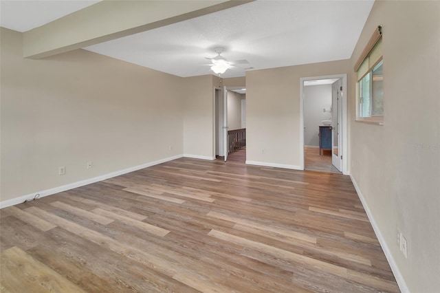 unfurnished room featuring light wood-type flooring, ceiling fan, and baseboards