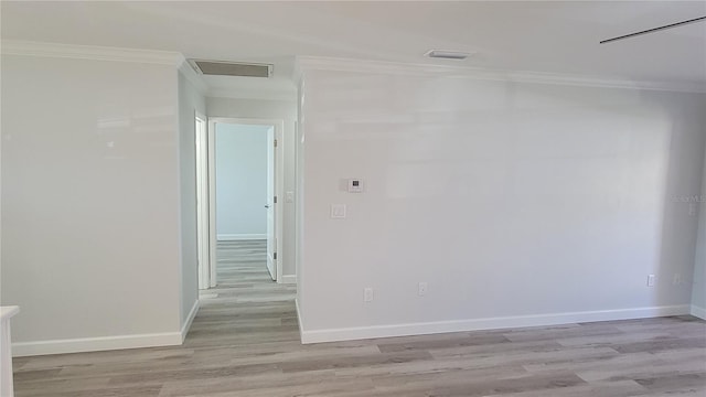 spare room featuring crown molding and light hardwood / wood-style flooring