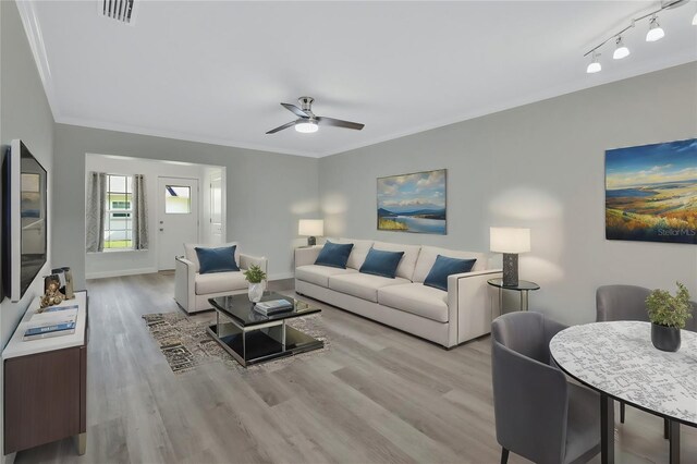 living room with crown molding, light hardwood / wood-style flooring, and ceiling fan