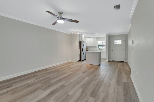 unfurnished living room with crown molding, light hardwood / wood-style flooring, and ceiling fan