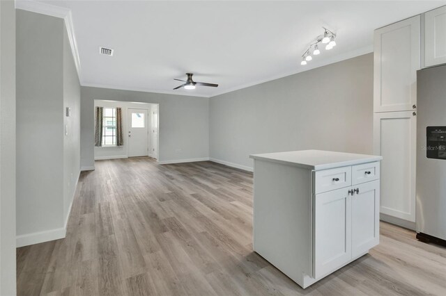 kitchen with white cabinets, stainless steel refrigerator, ceiling fan, and light hardwood / wood-style floors