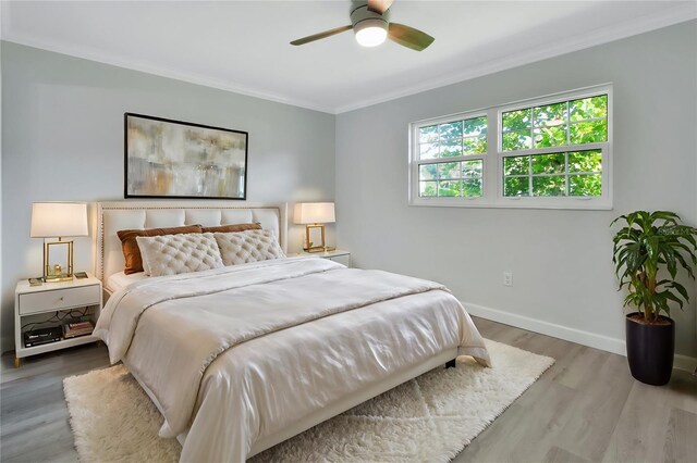 bedroom featuring ceiling fan, ornamental molding, and hardwood / wood-style flooring