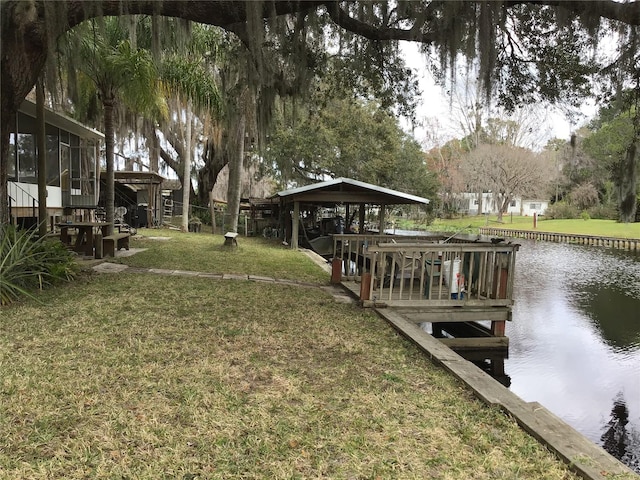 view of dock featuring a lawn and a water view