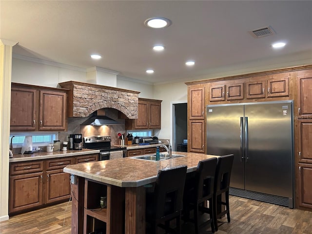 kitchen featuring a center island with sink, dark wood-type flooring, appliances with stainless steel finishes, and sink