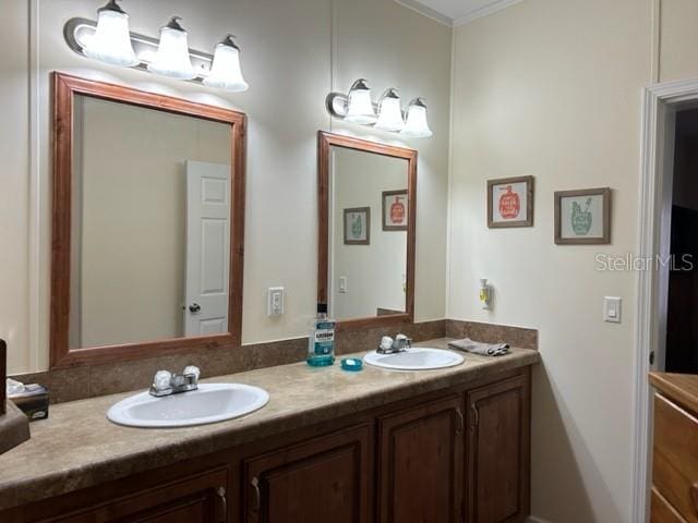 bathroom featuring double sink vanity and crown molding