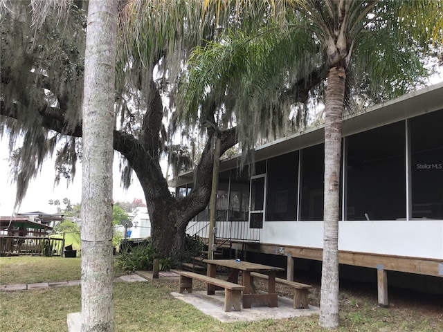 view of side of property with a lawn and a sunroom