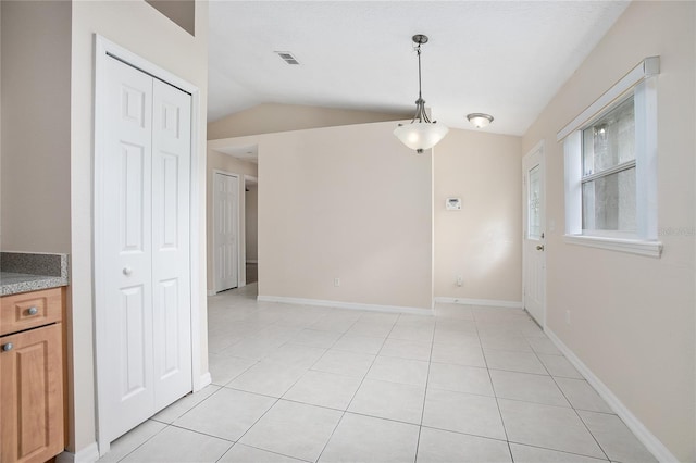 tiled empty room with vaulted ceiling