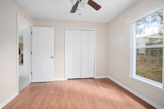 unfurnished bedroom featuring a closet, light hardwood / wood-style floors, and ceiling fan