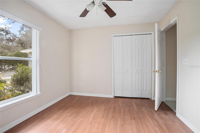 unfurnished bedroom featuring ceiling fan, a closet, and light hardwood / wood-style flooring