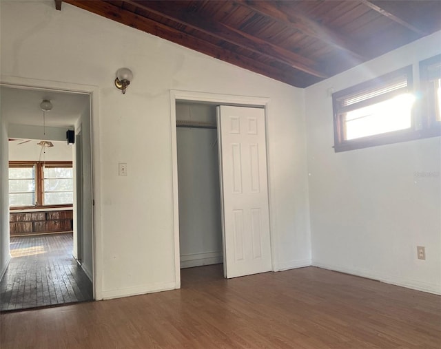 unfurnished bedroom with vaulted ceiling with beams, dark hardwood / wood-style floors, wooden ceiling, and a closet